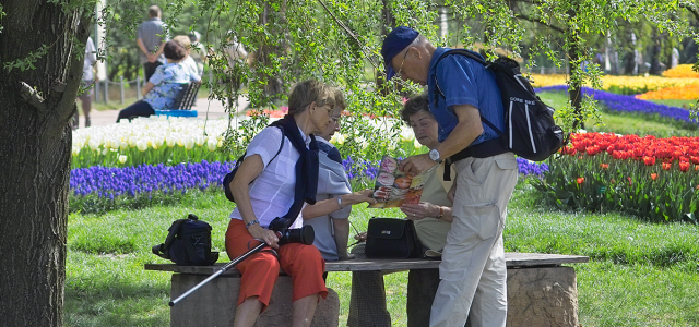 Gruppe von Senioren, die sich auf der Gartenschau mit einem Prospekt informiert