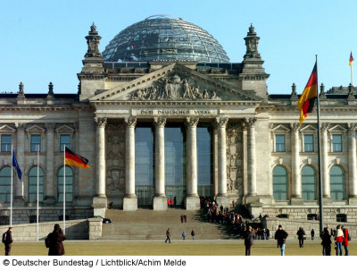 Der Deutsche Bundestag von vorne. Man kann gut die Menschenschlage erkennen, die darauf wartet in das Gebäude eingelassen zu werden.