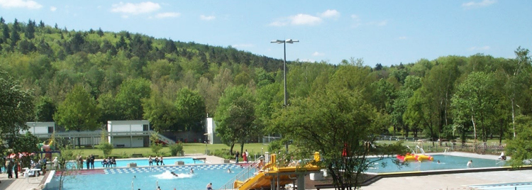 Badegäste schwimmen und planschen im Warmfreibad Kaiserslautern. 