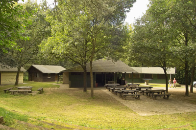 Die Grillhütte besitzt mehrere, fest eingebaute Tische mit Bänken, dazu ist der Grill und ein Teilbereich überdacht.
Links gibt es einen kleinen Grillbereich im Freien. 