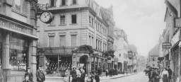 Die Marktstraße versetzt den Betrachter in das Jahr um 1890. Nicht nur die Mode der Leute, sondern auch die Bauart der Häuser mit den verspielten Fassaden lassen in ein ganz anderes Kaiserslautern blicken.