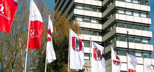 wehende Fahnen vor dem Kaiserslauterer Rathaus - Hochformatfahnen 4 mit Kaiserslauterer Wappen auf weißem Grund; 4 Fahnen zweigeteilt: rotes Logo auf weißem Grund und weißes Logo auf rotem Grund