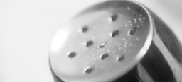 Silberner Spühlkopf mit Wassertropfen vor einem weißen Hintergrund