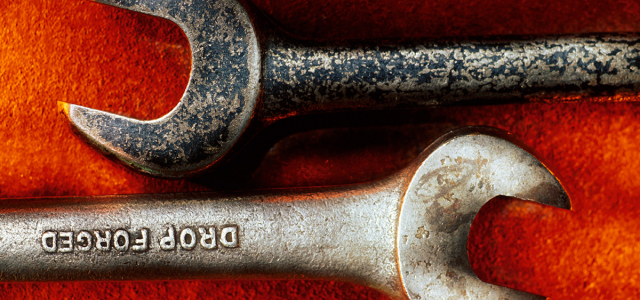 Zwei alte Werkzeugschlüssel auf einem rauen orangefarbenen Untergrund