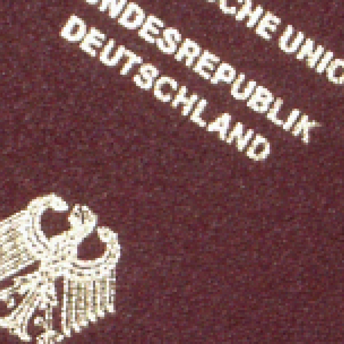 Das Bild zeigt einen neuen Reisepass der Bundesrepublik Deutschland, der gerade aus einer Schublade mit mehreren beantragten Reisepässen gezogen wird.