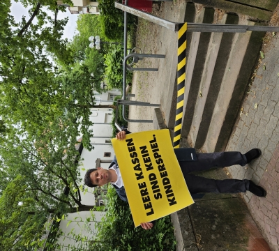 Beigeordneter Steinbrenner vor dem symbolisch gesperrten Spielplatz am Stockhausplatz