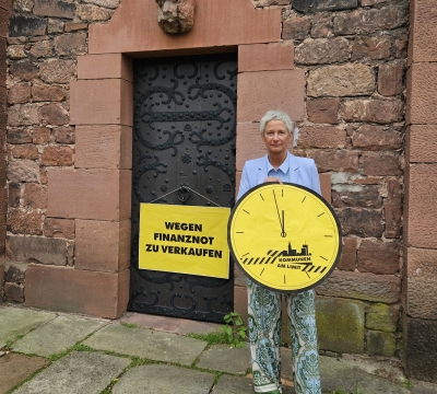 OB Kimmel vorm Casimirschloss, an dem das Schild hängt "Zu verkaufen"