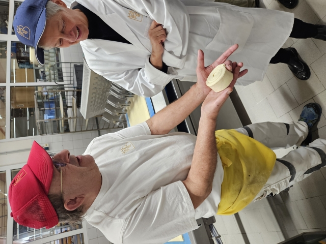 Der Bereichsleiter Feinbäckerei zeigt Beate Kimmel ein zusammengerolltes Stück Teig, das von der Laminiermaschine gefaltet wurde. © Stadt Kaiserslautern