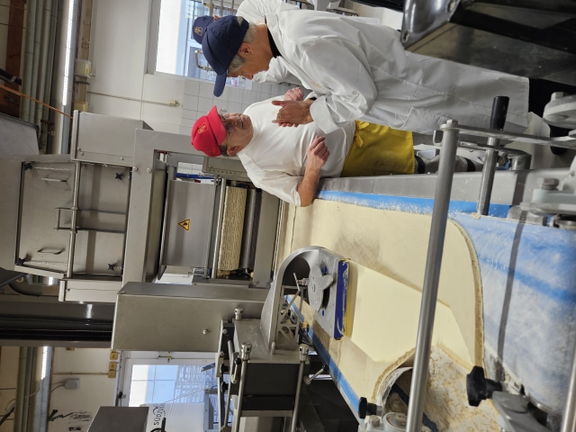 OB Kimmel bekommt vom Leiter der Feinbäckerei die Teiglaminiermaschine erklärt. © Stadt Kaiserslautern