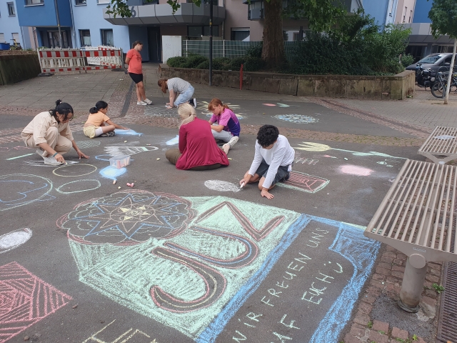 Für die Einweihungsfeier bemalten die Kinder und Jugendlichen den Platz der Kinderrechte mit Willkommensgrüßen. © Stadt Kaiserslautern