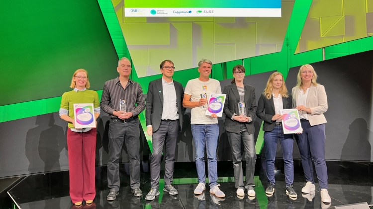 Die Siegerehrung auf der Bühne in Berlin. Links Justine Dambacher und Heinz Kirchmann mit Urkunde und der Trophäe für den 2. Platz. © Stadt Kaiserslautern