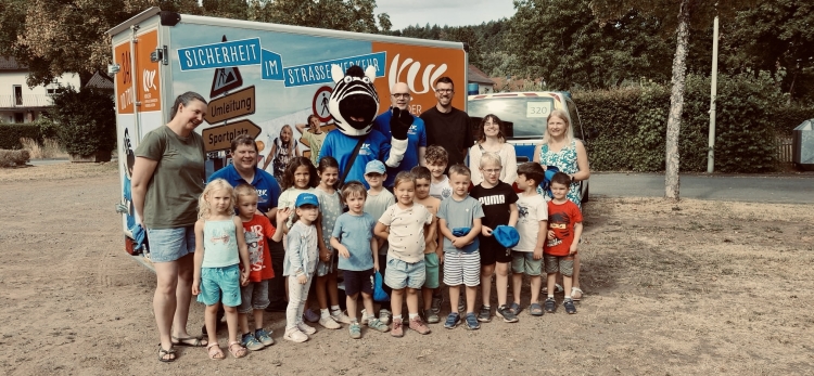 V.r.: Kita-Leiterin Gabriele Franzinger, Alissa Neder und Marco Zettl von EUROPE DIRECT Kaiserslautern, Markus Matheis, Maskottchen SAM und Erik Hippchen von der KUK sowie Caroline Moore, englischsprachige Fachkraft der Kita Waldwichtel, freuen sich mit den Kindern über den gelungenen Aktionstag. © Stadt Kaiserslautern