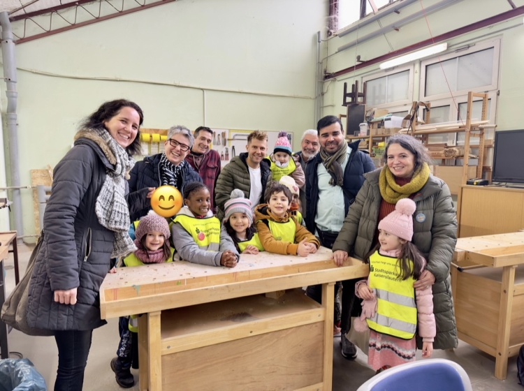 Auf dem Bild sind die Kinder mit ihren Erziehern, Vertretern des Jugendamts sowie Vertretern des ASZ in der Werkstatt zu sehen. © Stadt Kaiserslautern