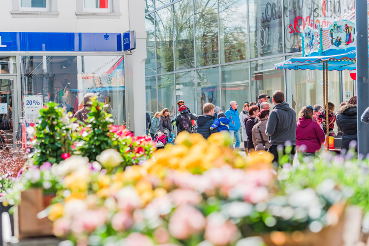 Archivbild von Lautern blüht auf. Menschen vor Ladenzeile. Im Vordergrund ein Blumenbeet.  © Werbegemeinschaft Kaiser in Lautern