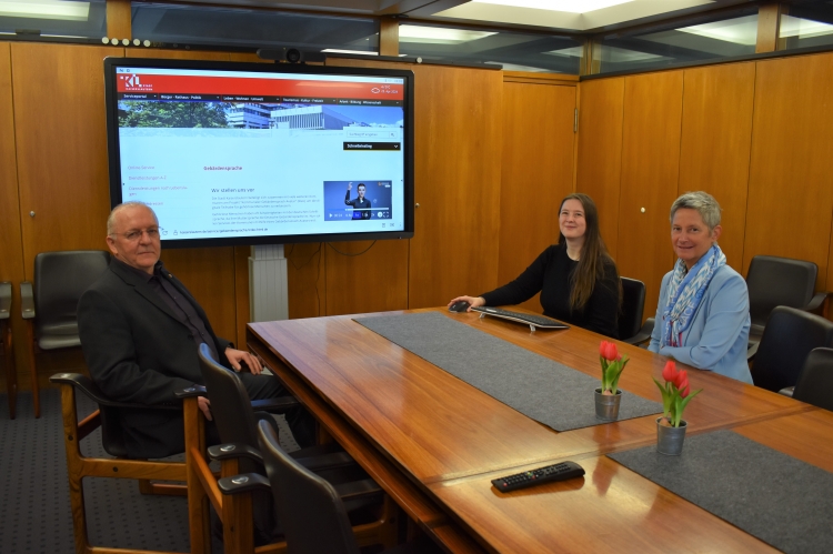 V.r.: Oberbürgermeisterin Beate Kimmel, Christina Horak-Hochreiter vom Referat Digitalisierung und Innovation und kommissarischer Referatsleiter Uwe Schmeer freuen sich über den neuen Gebärdensprach-Avatar. Dieser führt im Hintergrund die Gebärde für Kaiserslautern aus. © Stadt Kaiserslautern