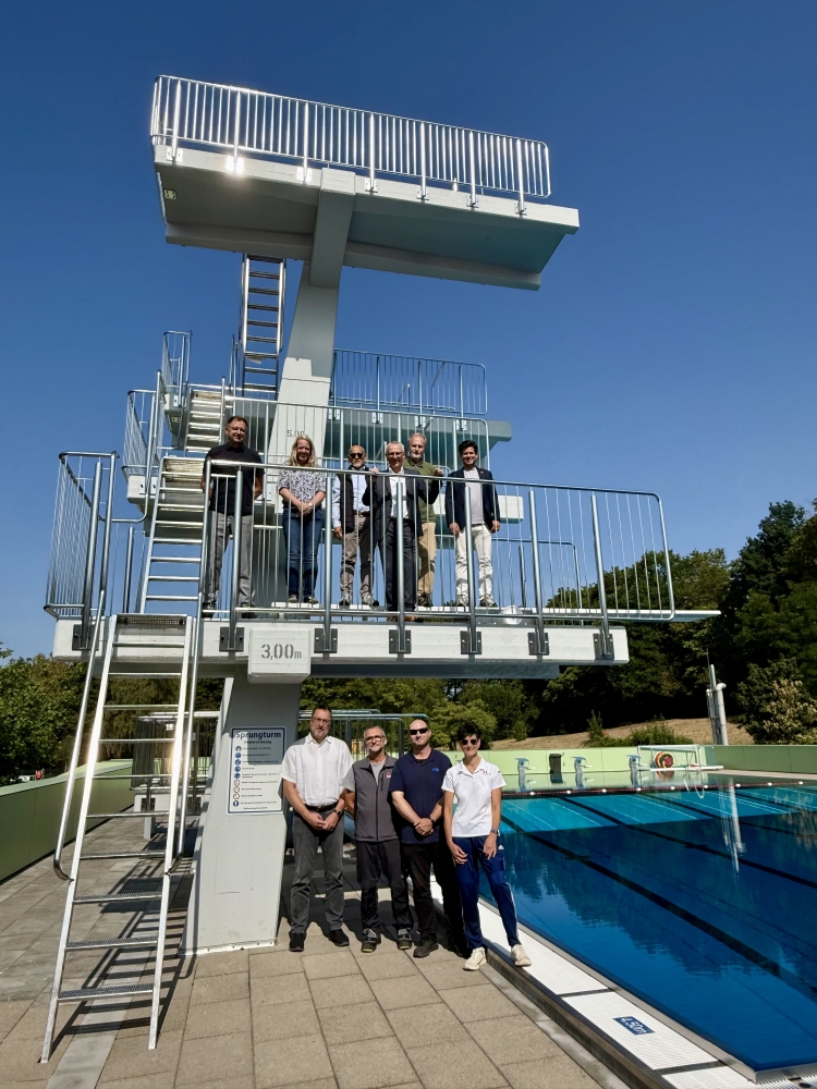 Alle am Sanierungsprojekt Beteiligten mit Manuel Steinbrenner (oben rechts) auf dem neuen Sprungturm am Springerbecken  © Stadt Kaiserslautern