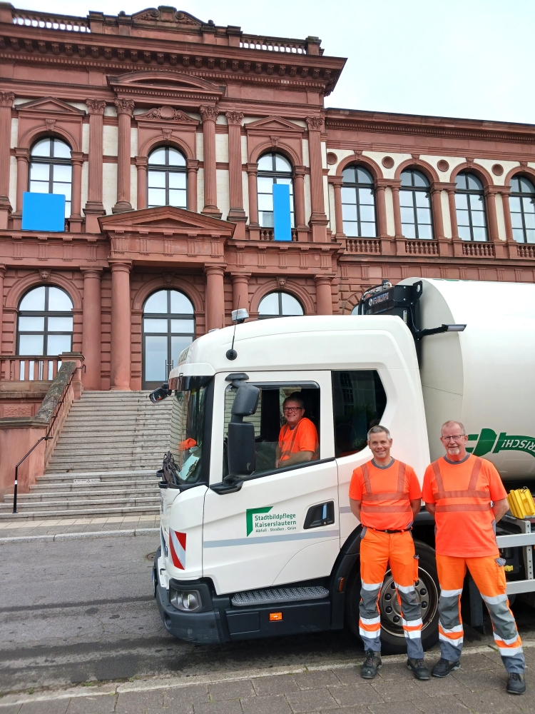 © Stadtbildpflege Kaiserslautern Ein Müllauto mit drei Mitarbeitern der Müllabfuhr vor der Pfalzgalerie. © Stadtbildpflege Kaiserslautern
