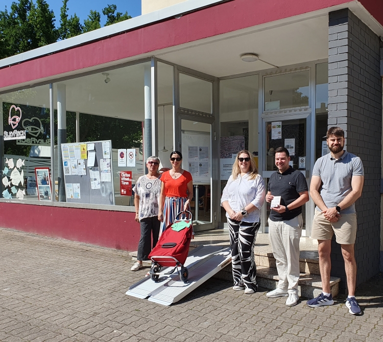 Die im Text genannten Personen stehen vor der Rampe. © Caritas