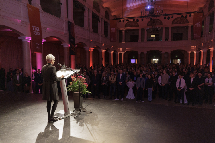 Beate Kimmel von hinten auf der Bühne vor dem voll besetzten Saal der Fruchthalle © view - die agentur