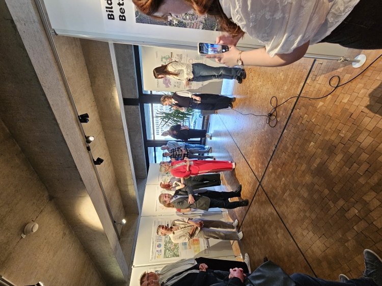 Zwei Studentinnen erläutern ihren Entwurf vor den Gästen der Ausstellungseröffnung. In der Mitte Prof. Holger Schmidt und OB Beate Kimmel. © Stadt Kaiserslautern