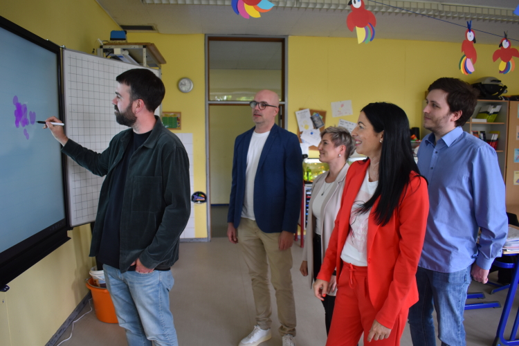 Beim Besuch in der Fritz-Walterschule wurden die neuen Panels direkt ausprobiert. Das Bild zeigt Konrektor Lukas Andes an der Tafel, dahinter Markus Matheis, Katrin Lanz und Christoph Wirth vom Referat Schulen und Schuldezernentin Anja Pfeiffer. © Stadt Kaiserslautern
