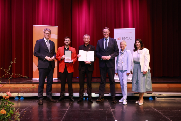 Die Mainzer Hofsänger erhalten die Zelter-Plakette für 100-jähriges Wirken. vlnr: Bundesverkehrsminister Patrick Schnieder, Vinzent Grimmel, Andreas Leuck (beide Mainzer Hofsänger), Ministerpräsident von Rheinland-Pfalz Alexander Schweitzer, Oberbürgermeisterin von Kaiserslautern Beate Kimmel, BMCO-Präsidentin Derya Türk-Nachbaur MdB. © Rolando de Sousa