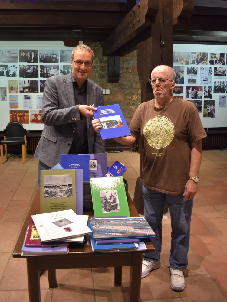 Bernd Klesmann, Leiter des Stadtmuseums und Stadtarchivs, nimmt die Bücher von Berthold Gehm entgegen. © Stadt Kaiserslautern