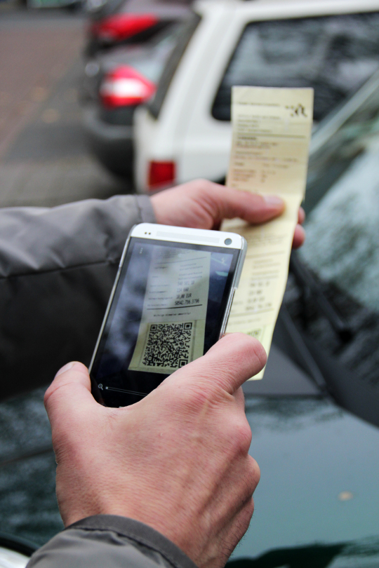 Ein Autofahrer scannt den QR-Code, der auf die Verwarnung aufgedruckt ist, mit seinem Smartphone. TraffGo Road/PayPal