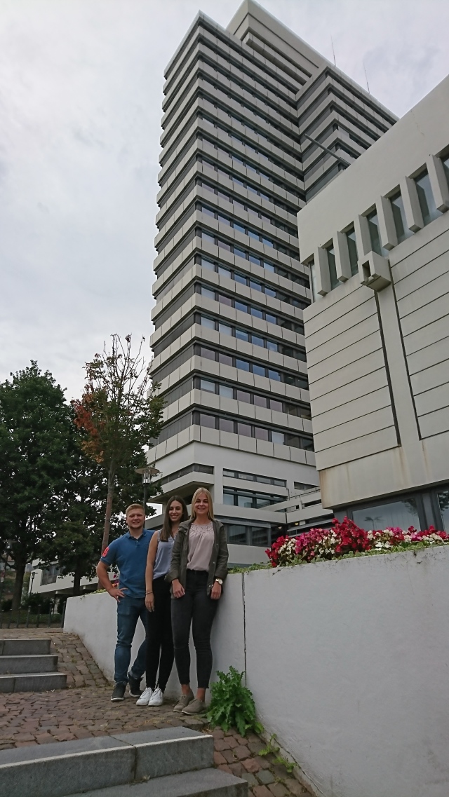 Marius Rudig, Lena Seitz und Ann-Kathrin Hauck vor ihrem 84 Meter hohen Ausbildungsplatz.  © Stadt Kaiserslautern