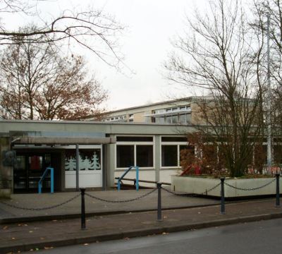 Frontansicht Schulgebäude mit blauen Treppengeländer