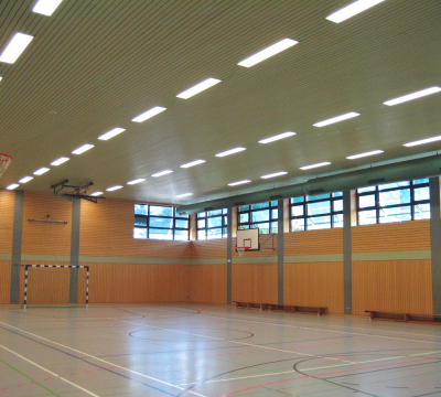 Sporthalle Innenansicht HSG - Halle mit Holzwänden, Oberlichter und zwei Basketballkörbe