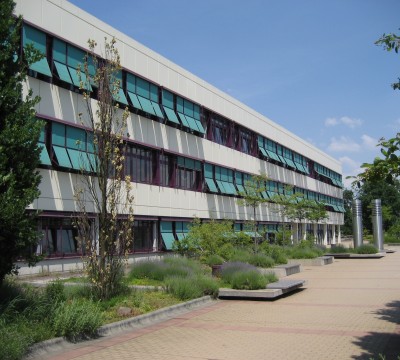 Außenfassade Hohenstaufen-Gymnasium im Sonnenschein mit ausgefahrenem Sonnenschutz an den Fenstern