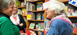 Drei Frauen im positiven Gespräch vor der Kinderbuchabteilung. 