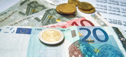 Euromünzgeld und Eurogeldscheine auf weißem Schriftstück