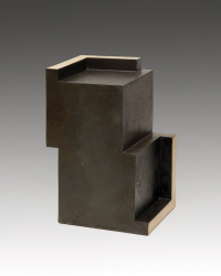 Eine Keramikskulptur, die aussieht, wie zwei versetzt aufeinanderliegende Würfel mit Vertiefungen.