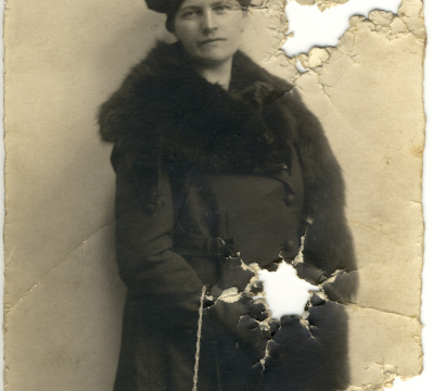 Das Foto zeigt Wilhelmina Jung in einem dunklen Mantel mit Pelzbesatz. Das Foto ist an drei Stellen durchlöchert.