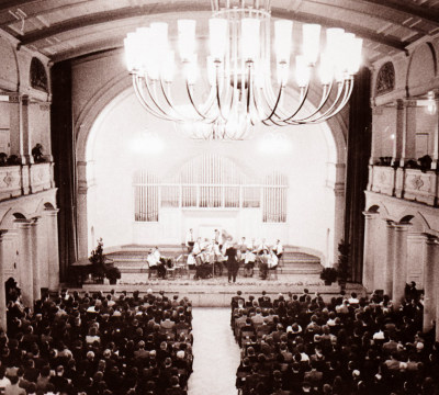 Eine schwarz-weiß Fotografie des großen Saals bei einer Aufführung.