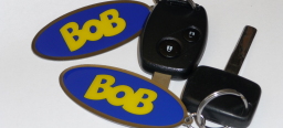 zwei Fahrzeugschlüssel mit dem BOB-Schlüsselanhänger: gelber Schriftzug 'BOB' auf blauem Grund