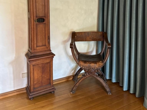 Eine hohe Standuhr und ein antiker Stuhl mit Lehne im Turmzimmer