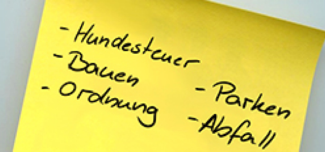 auf gelbem Zettel sind die Schlagwörter '- Hundesteuer', '- Bauen', '- Ordnung', ' - Parken' und '- Abfall' in Handschrift geschrieben