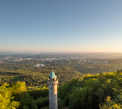 Blick auf den Humbergturm aus der Luft und dahinter die Stadt Kaiserslautern.