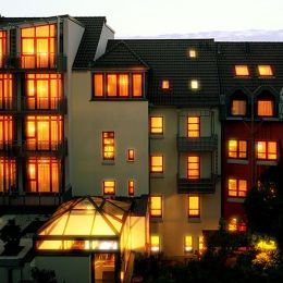 Die Zimmer des Hotels Zollamt leuchten von außen in warmen Farben. Einige Zimmer besitzen darüberhinaus auch einen Balkon.