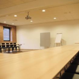 Der Tagungsraum bietet eine Flipchart, ein Whiteboard und viel Sitzmöglichkeiten für Tagungsteilnehmer.