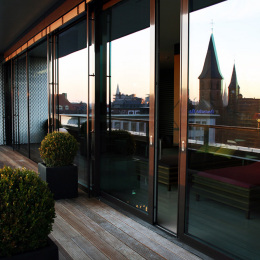 In the large windows of the roof terrace, the silhouette  of the city of Kaiserslautern is reflected.