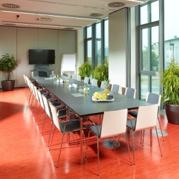 This conference room has a long table and at the end there is a flat-panel television.