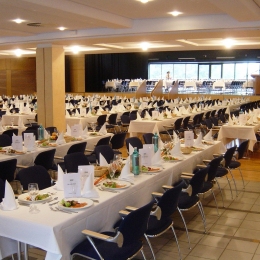 A large room with muted, long tables.