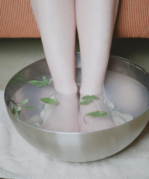 Fußbad – Füße in Schüssel mit Wasser.