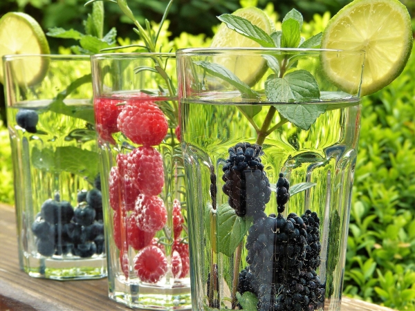 Gläser mit Wasser, versetzt mit frischem Obst.