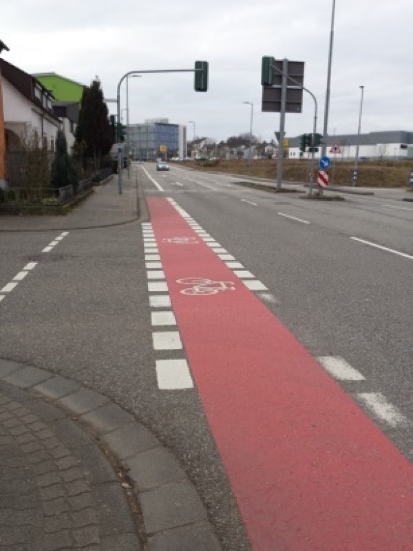 Rote Fahrbahnmarkierung für Radfahrer im Straßenraum